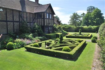 The house is a converted barn from 1911 into a mock Tudor house. The knot gardens either side of the front door help to confirm the history and give the garden and house a sense of place.