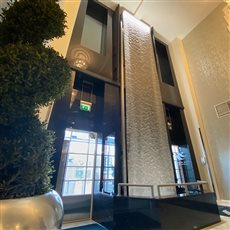 A tall AquaVeil® for the interior of this commercial building. Incredibly the AquaVeil® can be created to any height or width, and the material the water flows down is in one piece without joins, with a specifically designed lighting system