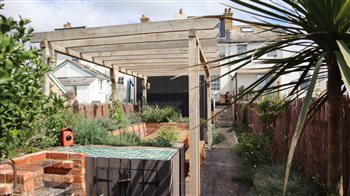 A long narrow coastal garden a stones throw from the beach with entertaining areas, a Koto sauna, gym, hot tub, outdoor shower, BBQ area and rugged gravel garden planting, lots on the client wish list!