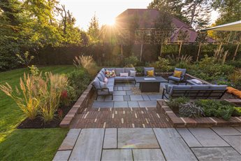 New sunken seating area for entertaining, surrounded by lush planting.
