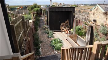 A long narrow coastal garden a stones throw from the beach with entertaining areas, a Koto sauna, gym, hot tub, outdoor shower, BBQ area and rugged gravel garden planting, lots on the client wish list!
