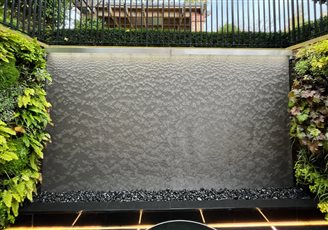 The AquaVeil® is not a mass-produced water wall, it’s a refined work of art. Each AquaVeil® is handmade in the UK, lending itself to bespoke sizes to integrate perfectly into its surroundings. Illustrated here with a living wall.